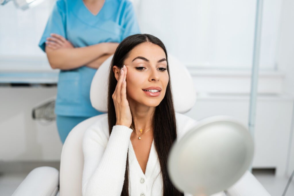 Woman with lifted brow looking in mirror at a med spa after a Botox brow lift