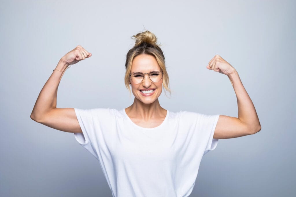 Woman in baggy white shirt raising in triumph