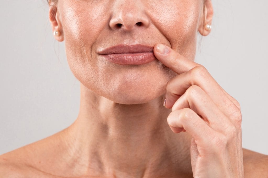 Close up of mature woman touching her lips